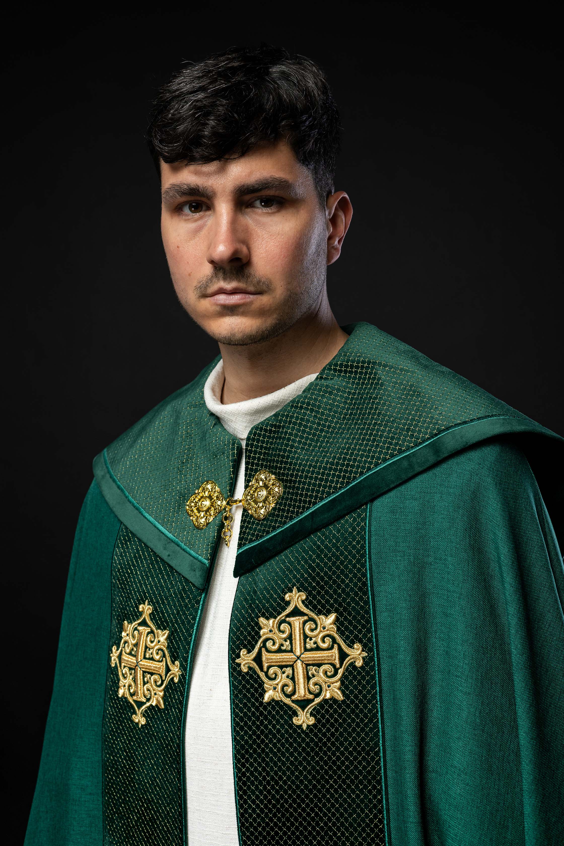 Green cope with a velvet sash and cross embroidery