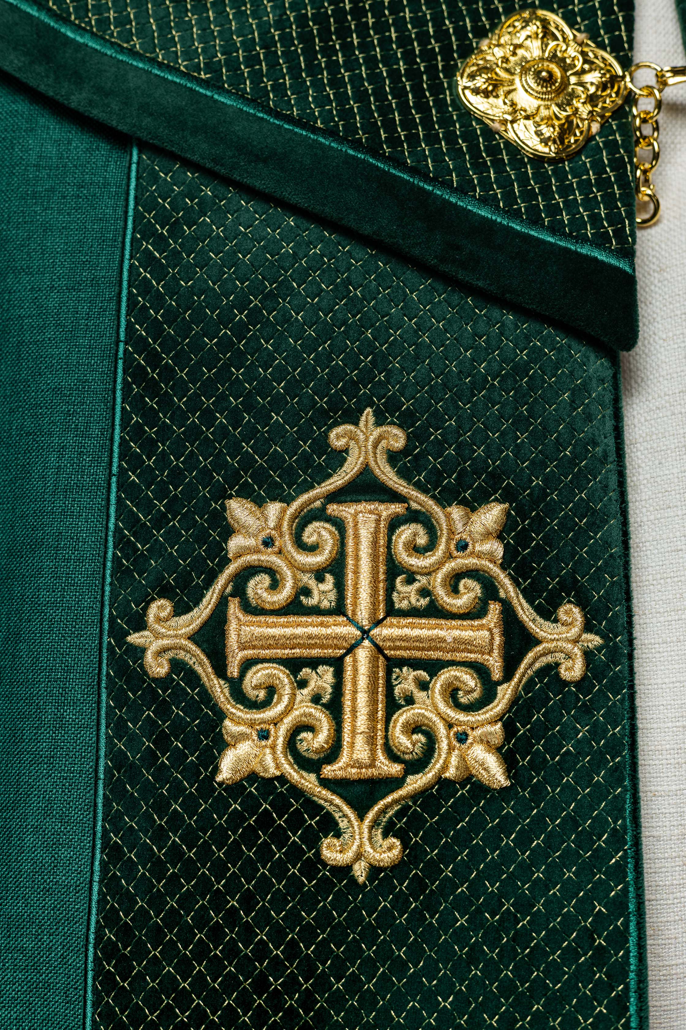 Green cope with a velvet sash and cross embroidery