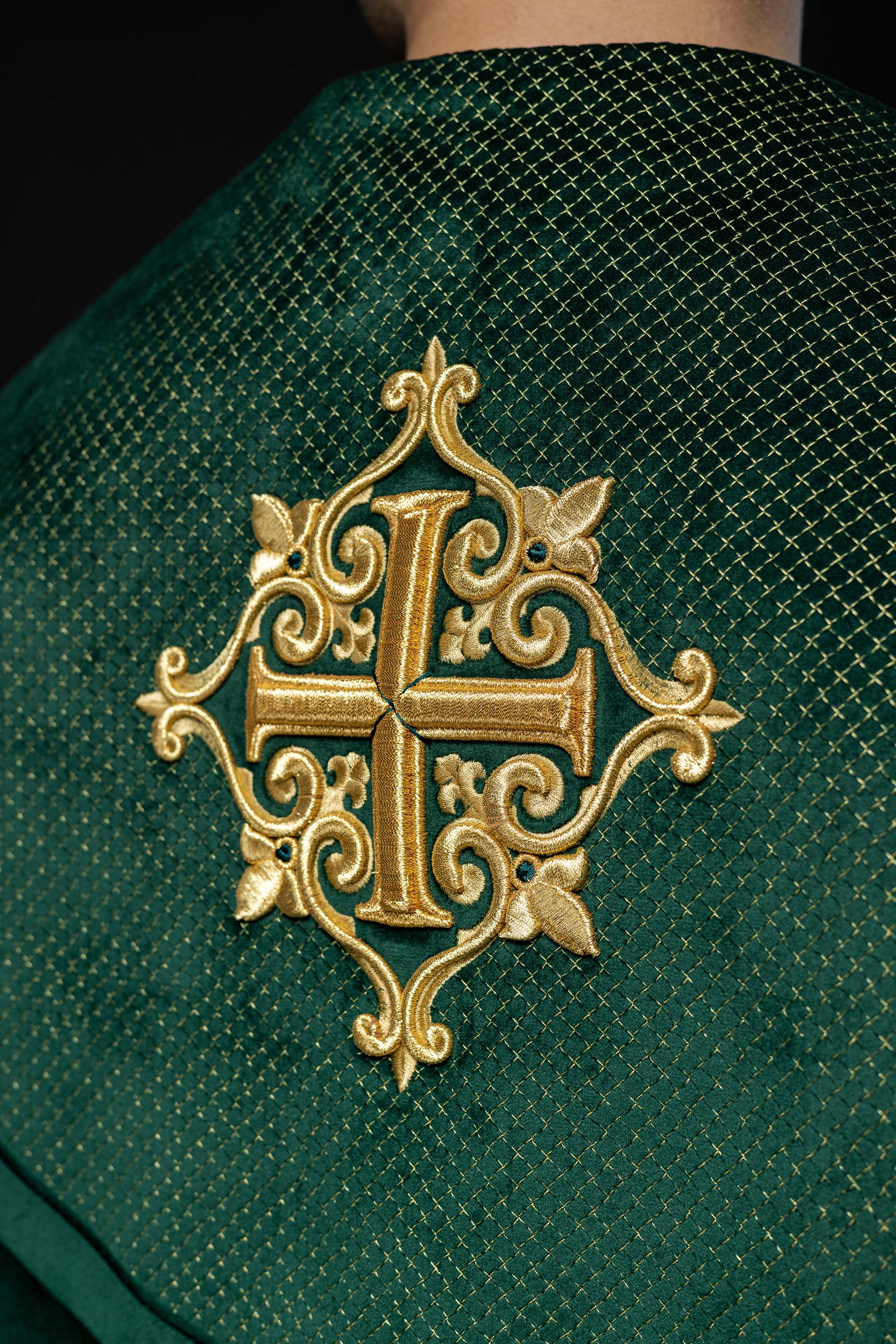Green cope with a velvet sash and cross embroidery