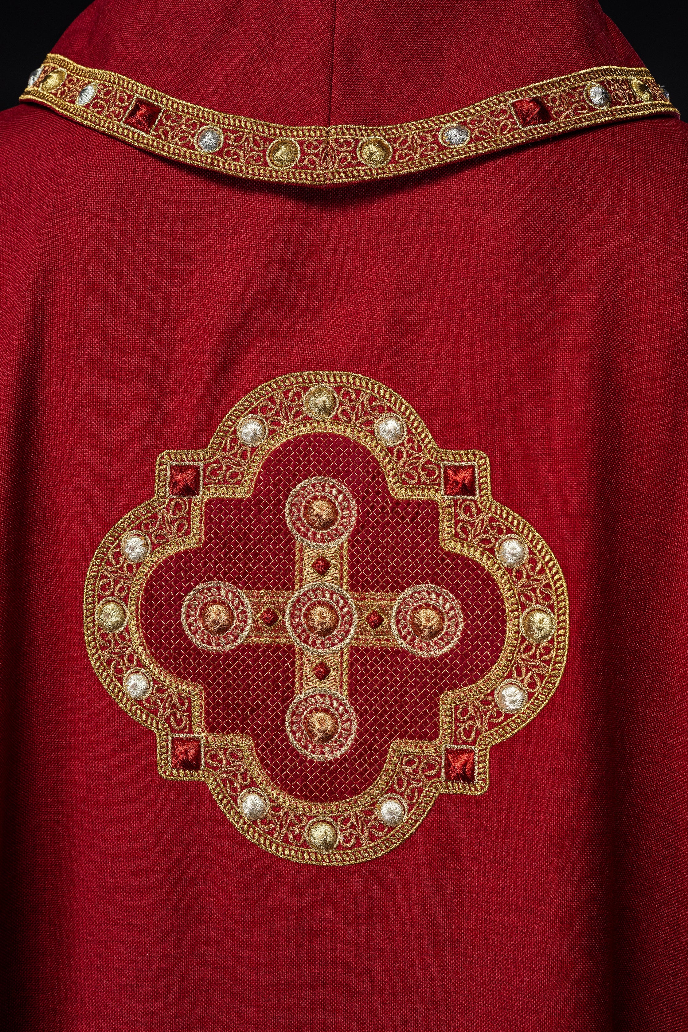 Chasuble in red with embroidered piping on the collar and around the embroidery of the cros