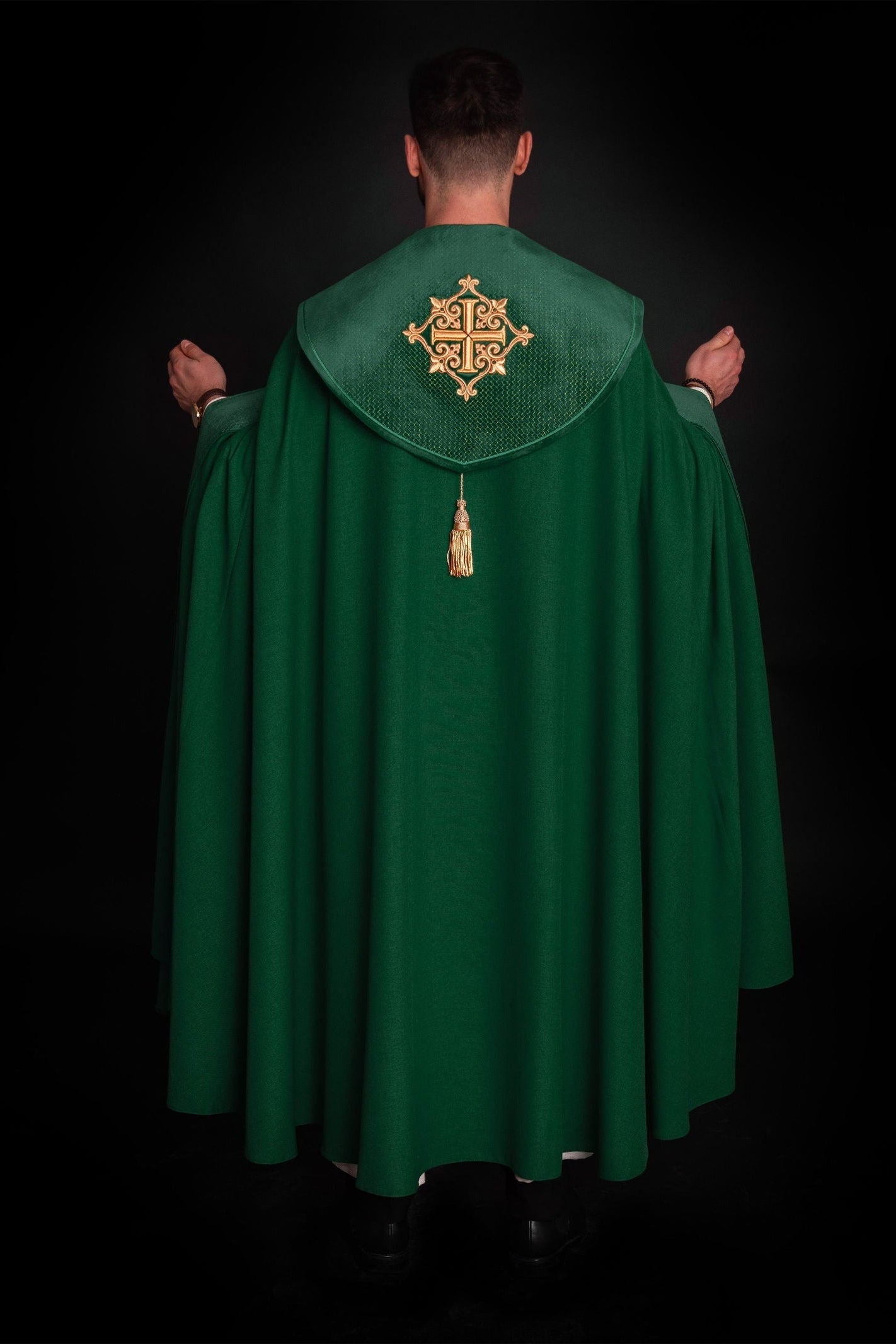 Green cope with a velvet sash and cross embroidery