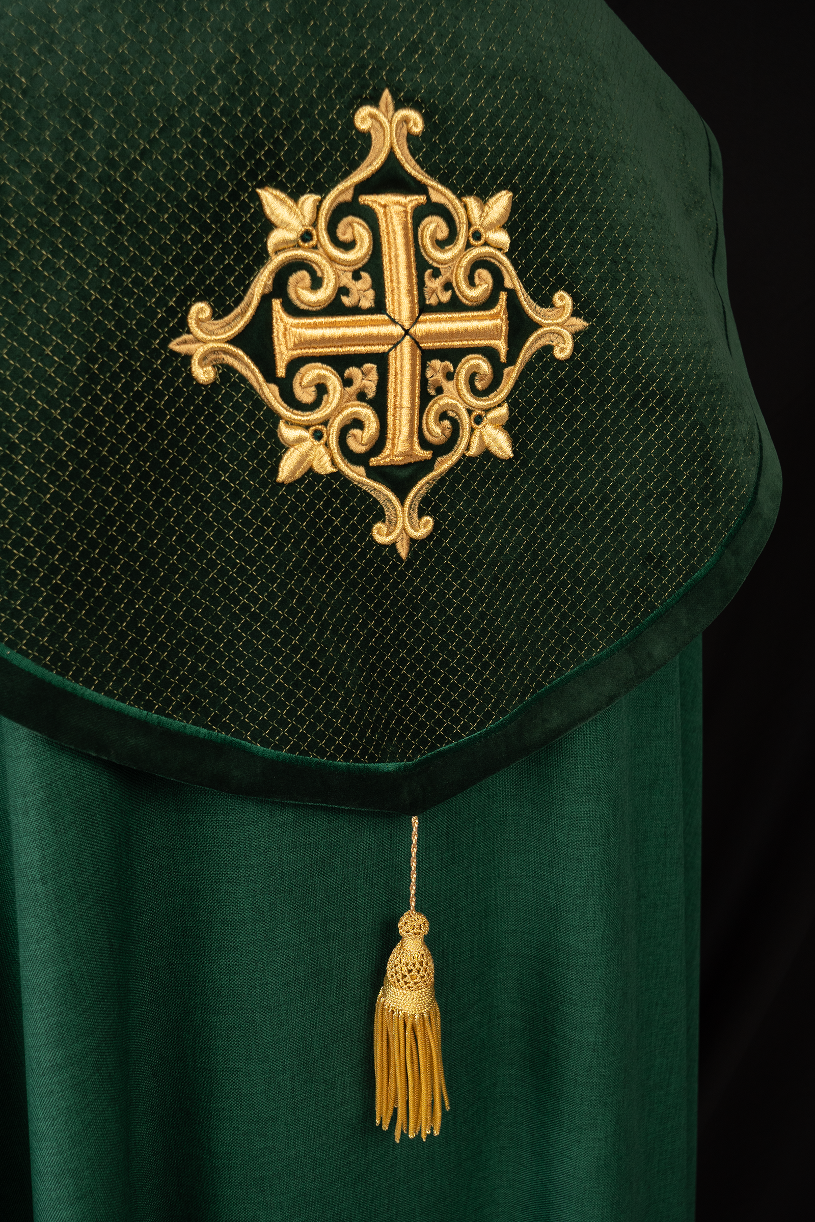 Green cope with a velvet sash and cross embroidery